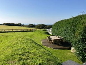 a wooden deck with two benches on top of a field at Ley Park in Bideford