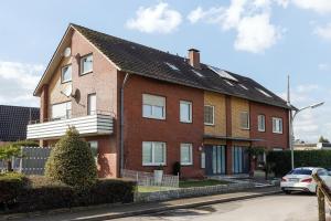 a red brick house with a car parked in front at VISTAMO Dorsten-Rhade, modernes Apartment in Dorsten