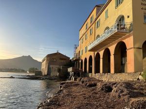 a group of buildings next to a body of water at Les Villas Maristella, Villa Goria in Aregno