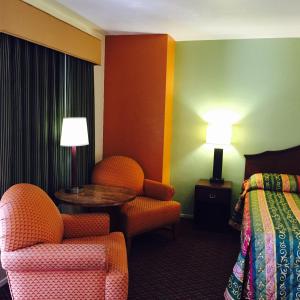 a hotel room with a bed and a chair and a table at Hacienda Motel in Yuma +18 photos