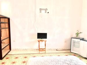 a room with a television and a table with a chair at Habitación con piscina en el centro de Mérida in Mérida