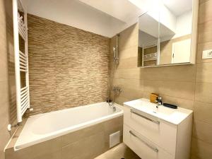 a bathroom with a tub and a sink and a bath tub at Lumial Mountain Nest in Braşov