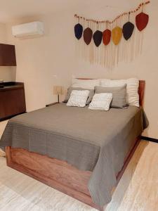 a bedroom with a large bed with two pillows at New Loft! Jungle Gym Best Pool in Tulum +33 photos