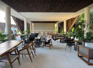 a restaurant with tables and chairs and tables and plants at New Loft! Jungle Gym Best Pool in Tulum