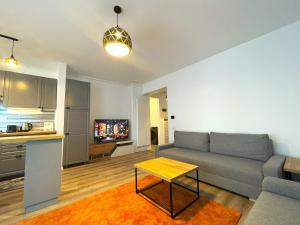 a living room with a couch and a table at Lumial Mountain Nest in Braşov
