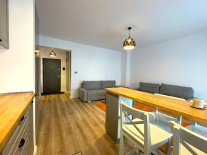 a kitchen and living room with a table and a couch at Lumial Mountain Nest in Braşov