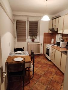 cocina con mesa y sillas y cocina con fogones en Relax apartman bg, en Belgrado