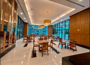 a dining room with tables and chairs and windows at The Elements Ampang Infinity Pool in Kuala Lumpur