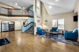 a lobby with blue chairs and a table and a staircase at Sleep Inn Springfield West in Springfield