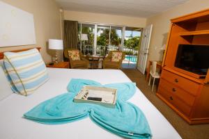 ein Hotelzimmer mit einem Bett und einem Laptop darauf in der Unterkunft Naples Garden Inn in Naples