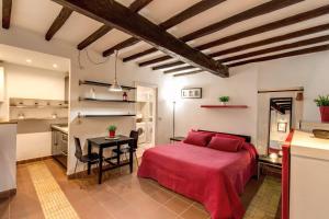 ローマにあるApartment Gaiaのベッドルーム1室(赤いベッド1台付)、キッチンが備わります。