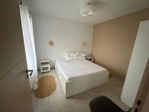 una camera da letto con un letto bianco in una stanza di Appartement avec jardin a Châteauneuf-de-Galaure