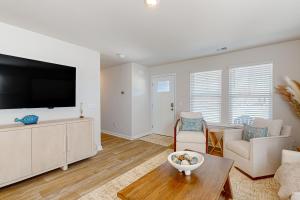 a living room with a large flat screen tv at Coastal Pines in Ocean Isle Beach