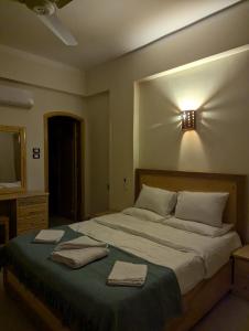 a bedroom with a large bed with two towels on it at Pharaohs Apartments in Luxor