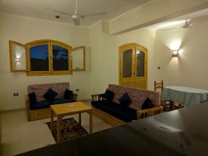 a living room with two couches and a table at Pharaohs Apartments in Luxor