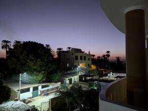 a view of a building at night with palm trees at Pharaohs Apartments in Luxor