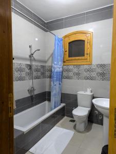 a bathroom with a toilet and a tub and a sink at Pharaohs Apartments in Luxor +44 photos