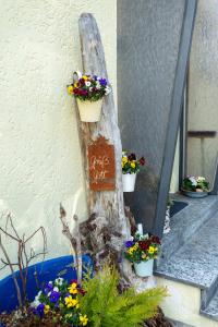 Un cartello su un tronco d'albero con fiori in secchi di Ferienwohnung Glückauf a Peiting