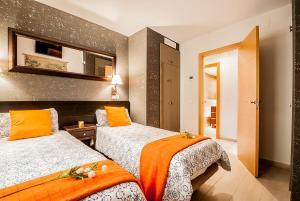 カディスにあるApartamento Vistabellaのベッドが2つと鏡があるホテルの部屋