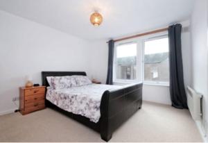 un dormitorio con una cama y una ventana en Harbour view 2 weeks City centre Apt, en Aberdeen