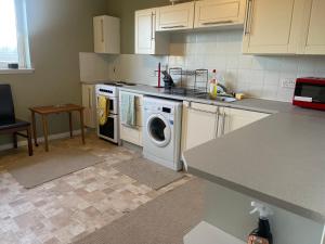 una cocina con lavadora y fregadero en Harbour view 2 weeks City centre Apt, en Aberdeen