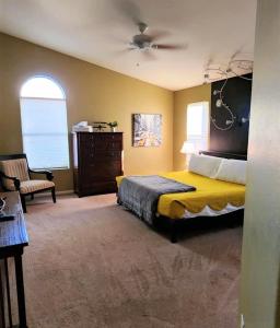 a bedroom with a bed and a chair in it at Quiet desert getaway with ping-pong, BBQ, citrus in Phoenix