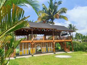 a pavilion with surfboards on it with a palm tree at Linkgreen Homestay Lombok in Tetebatu