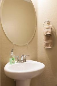 een badkamer met een witte wastafel en een spiegel bij Gated townhouse with heated pool, hot tub, near US60 in Mesa
