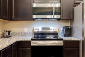 een keuken met een fornuis en een magnetron bij Gated townhouse with heated pool, hot tub, near US60 in Mesa