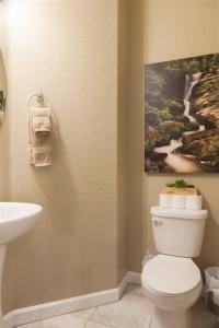 een badkamer met een toilet en een schilderij aan de muur bij Gated townhouse with heated pool, hot tub, near US60 in Mesa +30 foto's