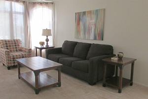 a living room with a couch and a table at Cozy house near I-10 with pool heater, hot tub, BBQ in Goodyear +13 photos