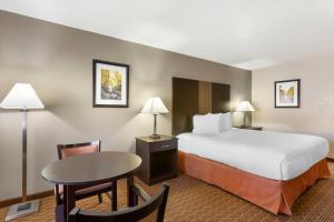 a hotel room with a large bed and a table at Best Western Sawmill Inn in Heber