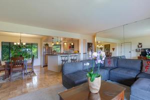 a living room with a blue couch and a kitchen at Alii Kai II 8H in Princeville
