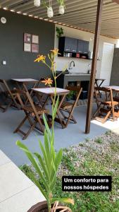 eine Terrasse mit einem Tisch, Stühlen und einer Pflanze in der Unterkunft Pousada Recanto Som do Mar in Caraguatatuba