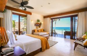 a bedroom with a bed and a view of the ocean at La Zebra Tulum, a Small Luxury Hotel in Tulum +107 photos