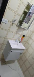 a bathroom with a white sink and a mirror at 11Suites casa Suite #6 in Caraguatatuba