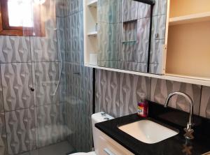 a bathroom with a sink and a shower at Sobradinho Completo a 150 m da Praia in São Lourenço do Sul