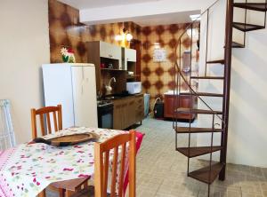 a kitchen with a table and a white refrigerator at Sobradinho Completo a 150 m da Praia in São Lourenço do Sul