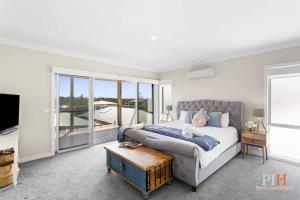 a bedroom with a bed and a tv and a table at Coastal Family Retreat in CW in Cape Woolamai