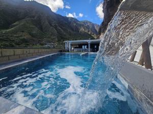 a water fountain in a pool with mountains in the background at Villa Los Zarzales in Güimar