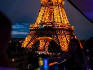 a woman standing in front of the eiffel tower at night at Pullman Paris Tour Eiffel in Paris