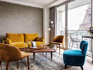 a living room with a couch and chairs and the eiffel tower at Pullman Paris Tour Eiffel in Paris