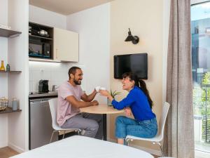 TV a/nebo společenská místnost v ubytování Aparthotel Adagio Access Paris Asnières