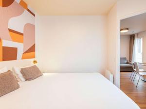 Postel nebo postele na pokoji v ubytování Aparthotel Adagio Access Paris Asnières