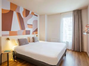 Postel nebo postele na pokoji v ubytování Aparthotel Adagio Access Paris Asnières