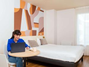 Postel nebo postele na pokoji v ubytování Aparthotel Adagio Access Paris Asnières