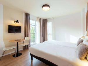 Postel nebo postele na pokoji v ubytování Aparthotel Adagio Access Paris Asnières