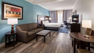 a hotel room with a couch and a bed at Best Western Plus Ambassador Suites in Venice +23 photos