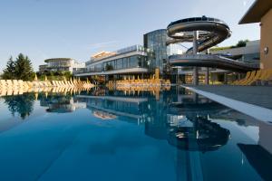 a pool with a water slide in front of a building at life-stegersbach Suites in Stegersbach