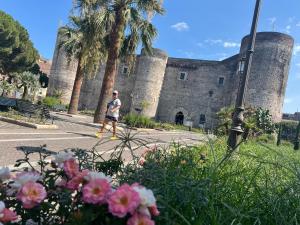 a man walking down a street in front of a castle at Elephant and Castle - Exclusive Holiday Home in Catania